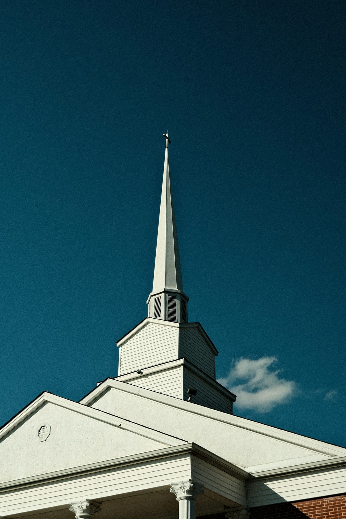 A white steeple against a deep blue sky